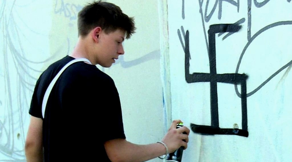 Berlin street artist group cleverly undo swastika graffiti