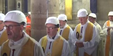 Priests wear hard hats at Notre-Dame