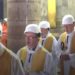 Priests wear hard hats at Notre-Dame