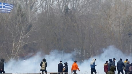 Greek and Turkish police fire tear gas as migrants try to cross into Greece