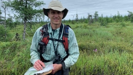 Scientist ankle-deep in bog water to better understand unique wetland