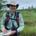 Scientist ankle-deep in bog water to better understand unique wetland